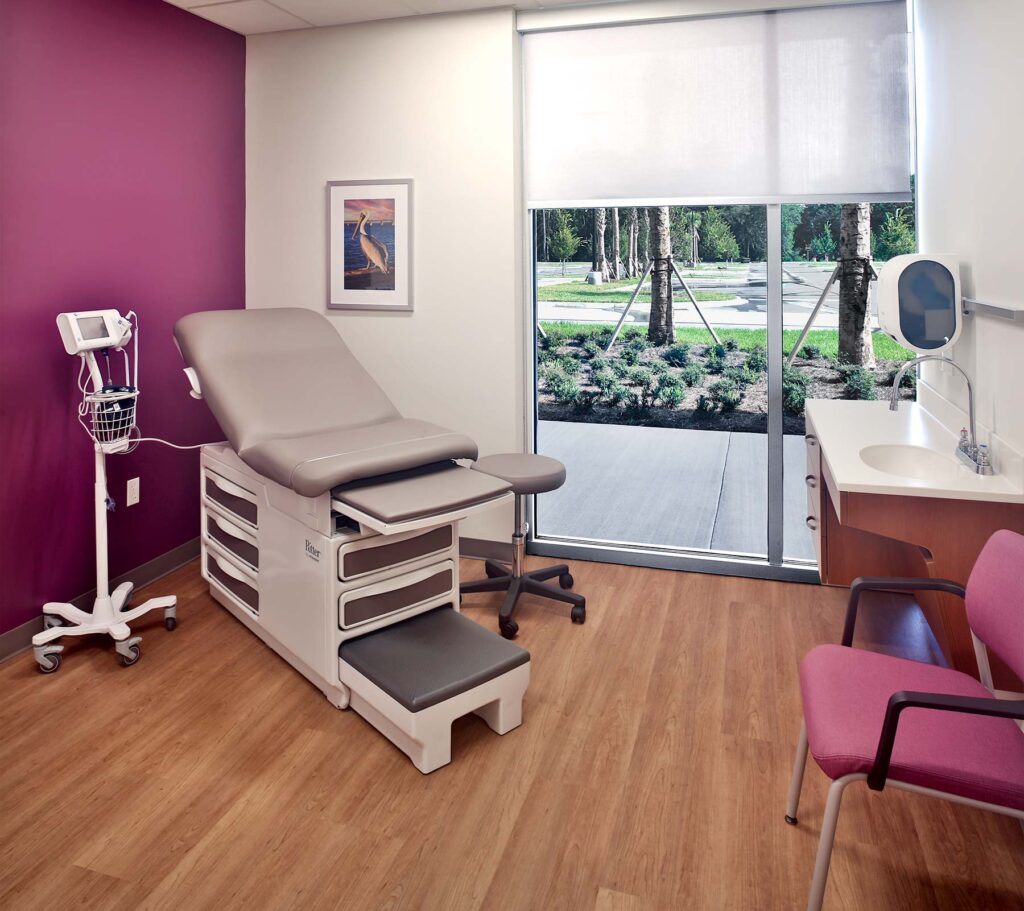 Modern medical patient rooms with empty desks, examination table and wooden floors within the Ascension St. Vincent’s building.