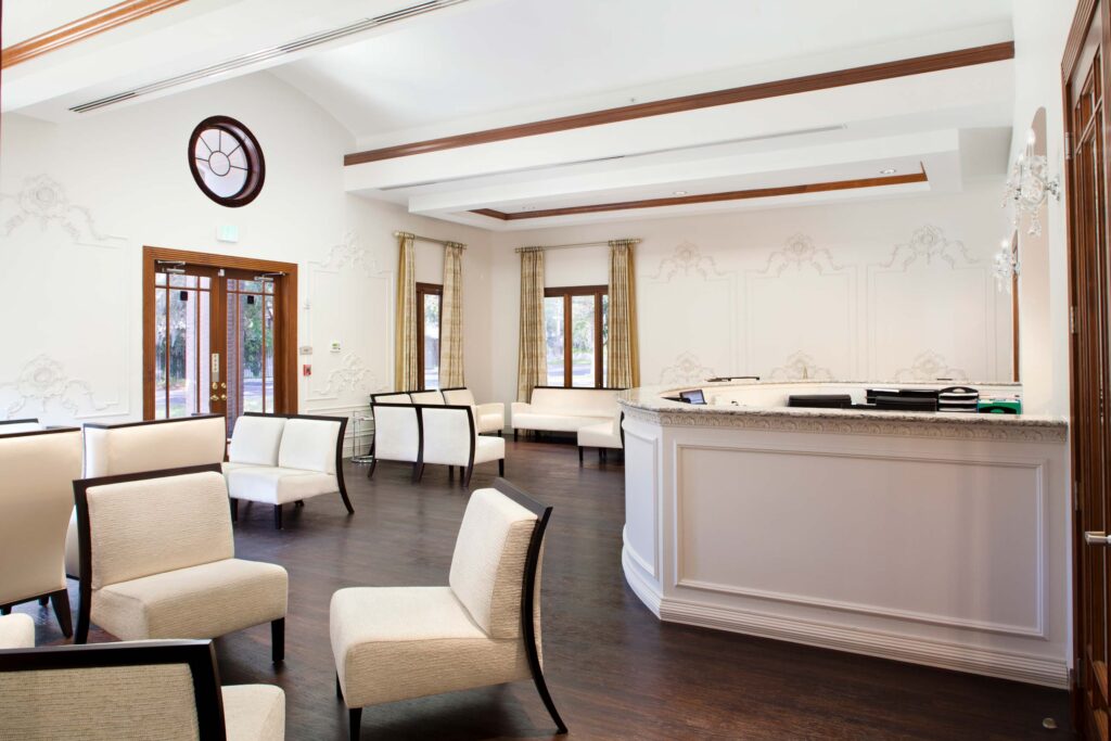 The lobby and front desk at Riverside Endoscopy, styled with dark wood ceiling highlights and elaborate molding on the walls.